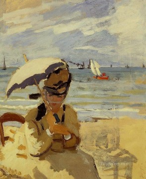 クロード・モネ Painting - トルヴィルの浜辺に座るカミーユ クロード・モネ